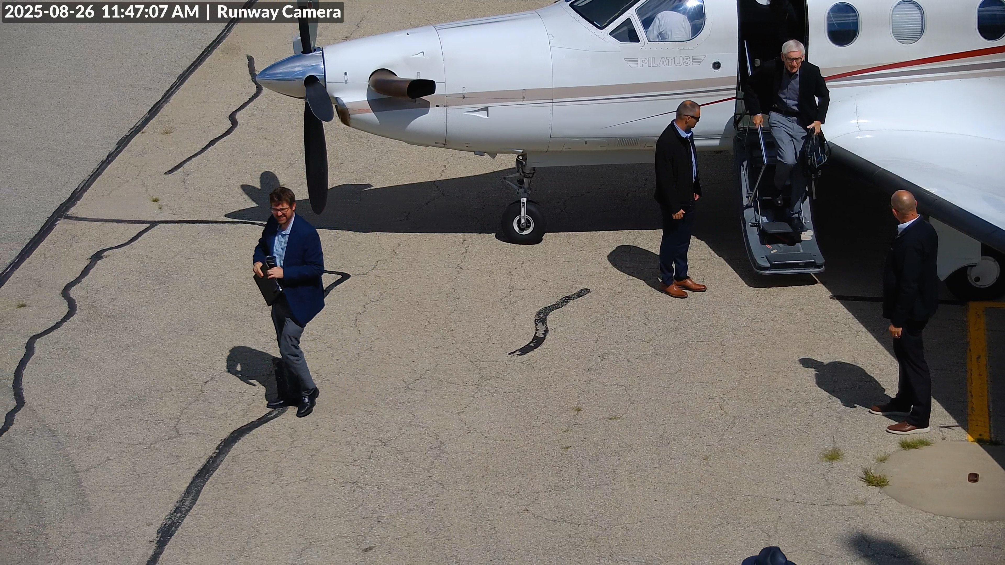 Runway camera view showing passengers exiting an aircraft on the tarmac